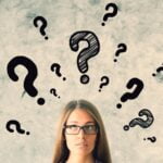 Nachdenkliche junge Frau mit Brille vor einer Wand voller gezeichneter Fragezeichen